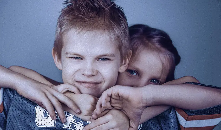 due fratelli preasolescenti che si abbracciano